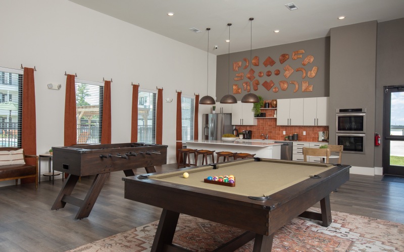 a clubroom with a pool table and chairs