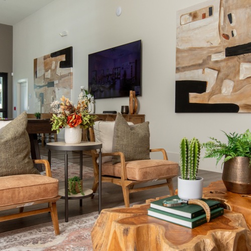 a clubroom with a couch, chairs, tables and a rug