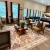 a clubroom with a couch, chairs, tables and a rug